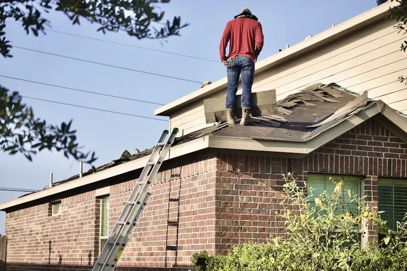 Professional roofer working on a residential roof in Lena